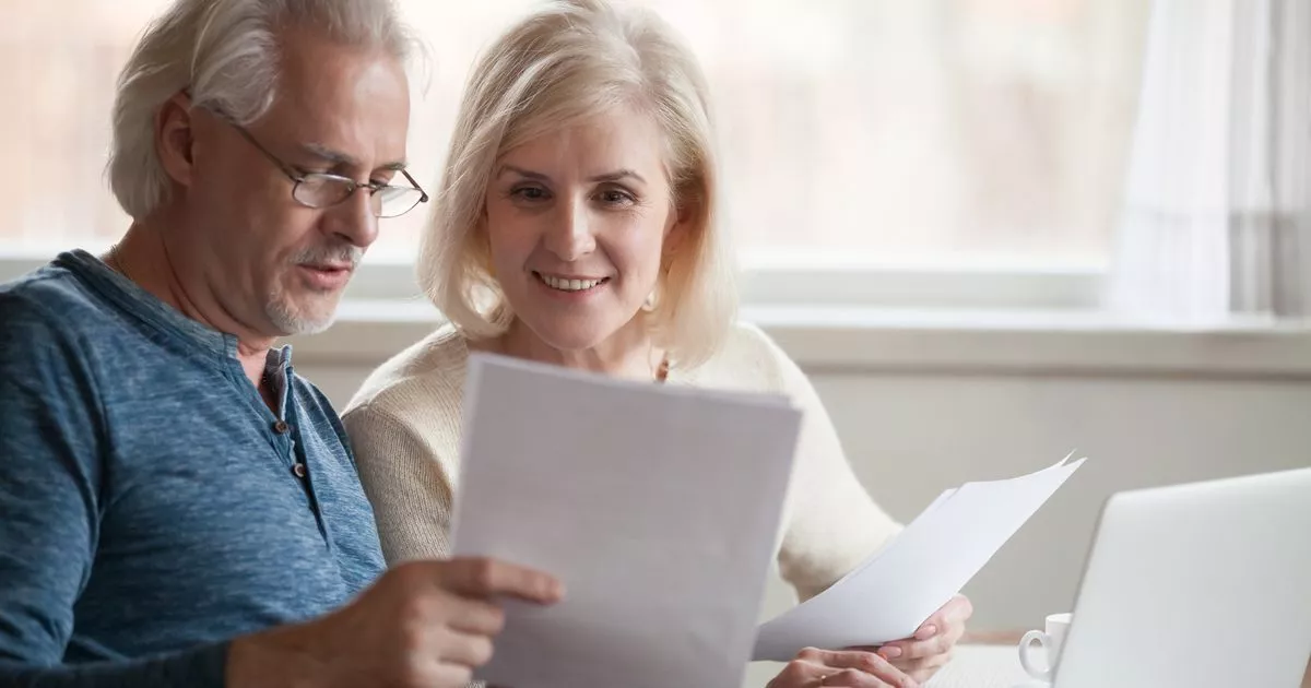 0 Happy older aged couple holding reading good news in document.jpg