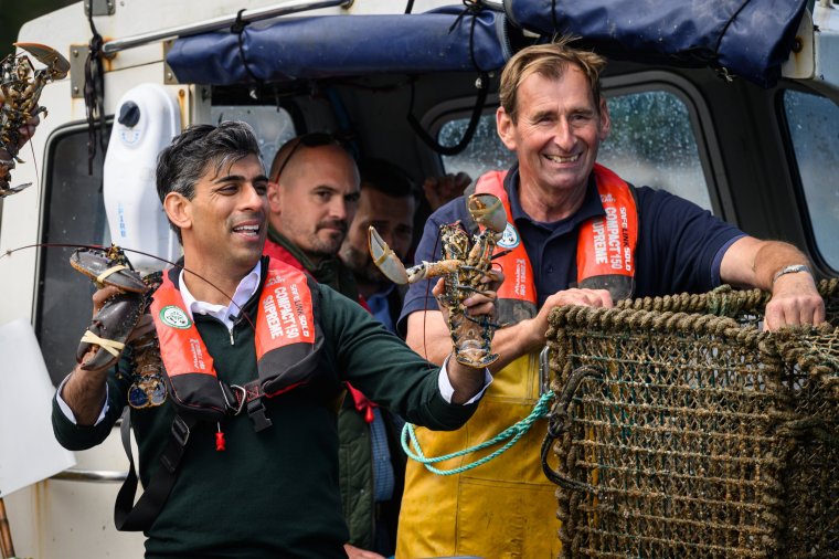 CLOVELLY, UNITED KINGDOM - JUNE 18: Prime Minister Rishi Sunak hold two lobsters while riding on a boat in the harbour at Clovelly as they collect lobster pots on June 18, 2024 Clovelly, United Kingdom. North Devon has been held by the Conservative Party since the 2015 general election. (Photo by Leon Neal/Getty Images)